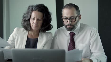 experienced businesspeople sitting and discussing documents