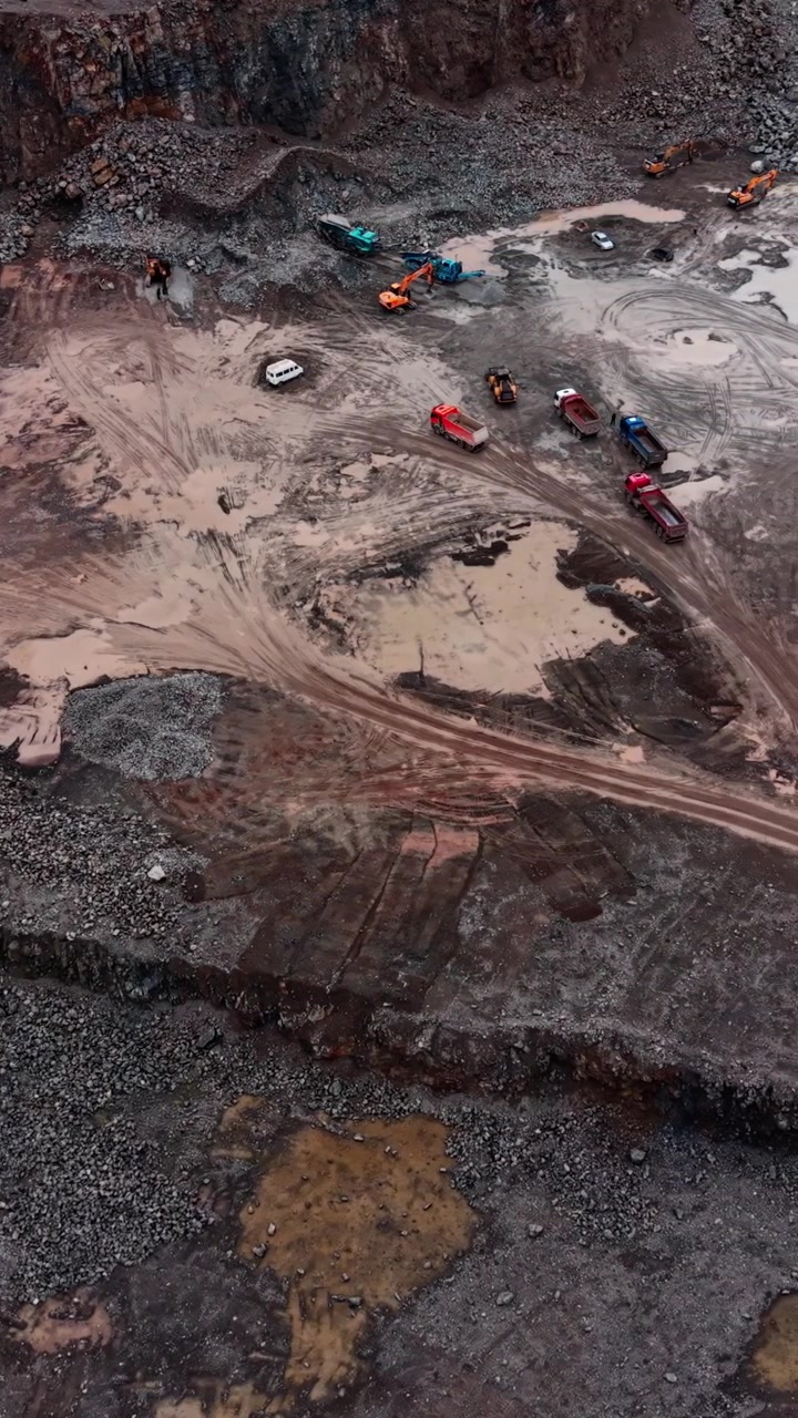 Aerial View of Heavy Machinery and Trucks Working in a Stone Quarry
