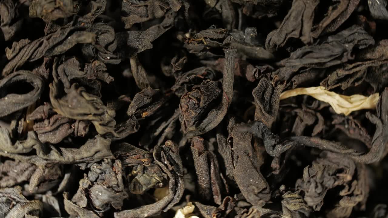 hojas de té negro de cerca. rotación de bucle