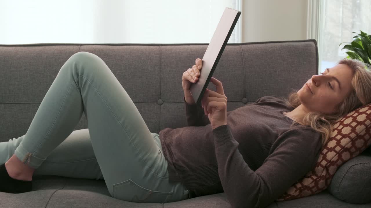 Young Millennial woman typing on her tablet