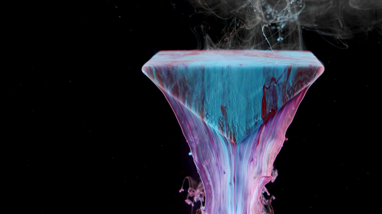 Multicolored ink paint slowly flows from the prism underwater