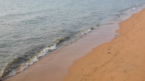 ocean waves along the sandy shores of bangsaray in pattaya, thailand