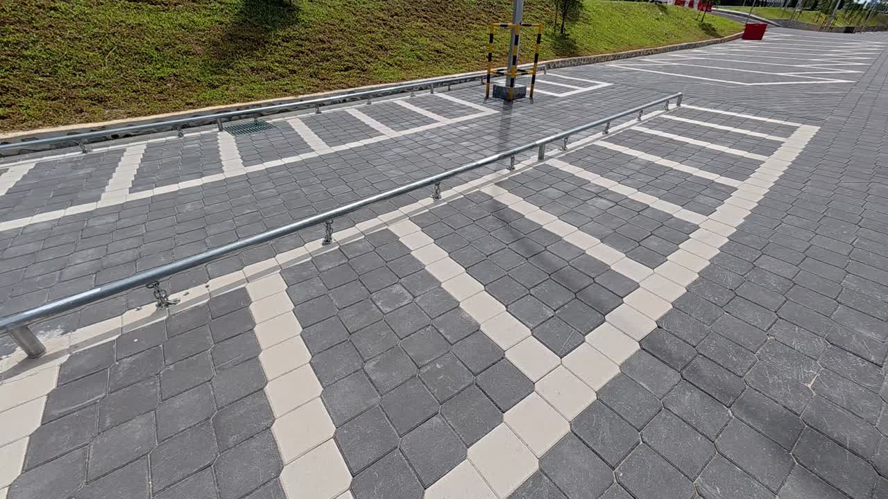 Empty motorcycle parking bays are bathed in sunlight, with no shade available. The parking area is currently unoccupied.