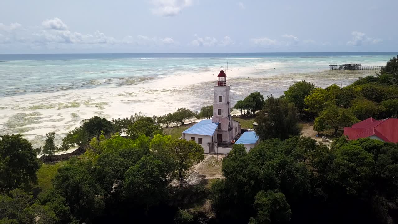 Aerial flying towards lighthouse, beach during low tide in background, Zanzibar