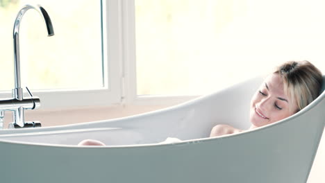 woman relaxing in a bathtub filled with bubbles