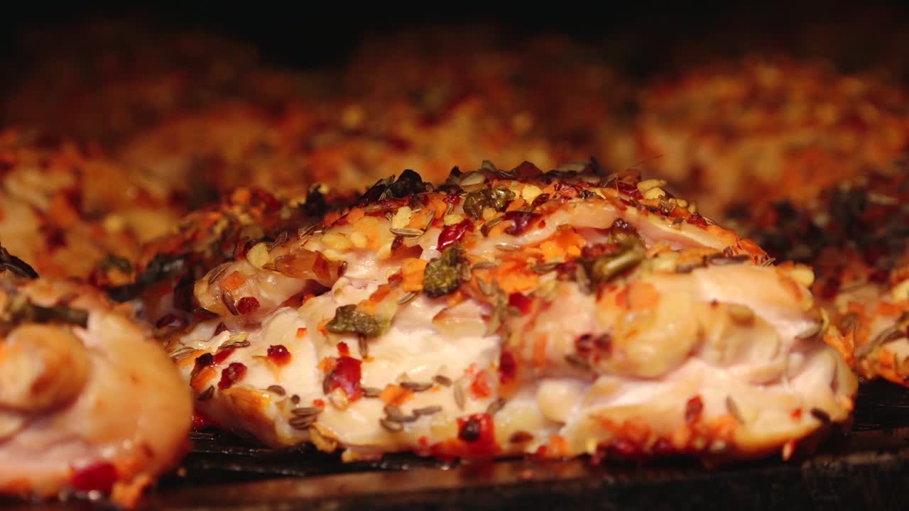 A large batch of golden-brown smoked chicken wings arranged on a grill rack. The wings appear juicy and well-cooked, ideal for barbecue or party servings.