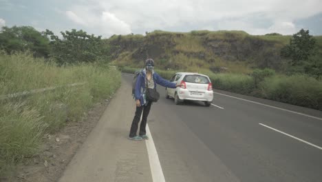 a hitch-hiking solo backpacking traveller struggling to get any lifts due to the post-pandemic fear of sharing rides with strangers in 4k slow motion