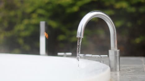 la corriente de agua disminuye gradualmente desde un grifo al aire libre
