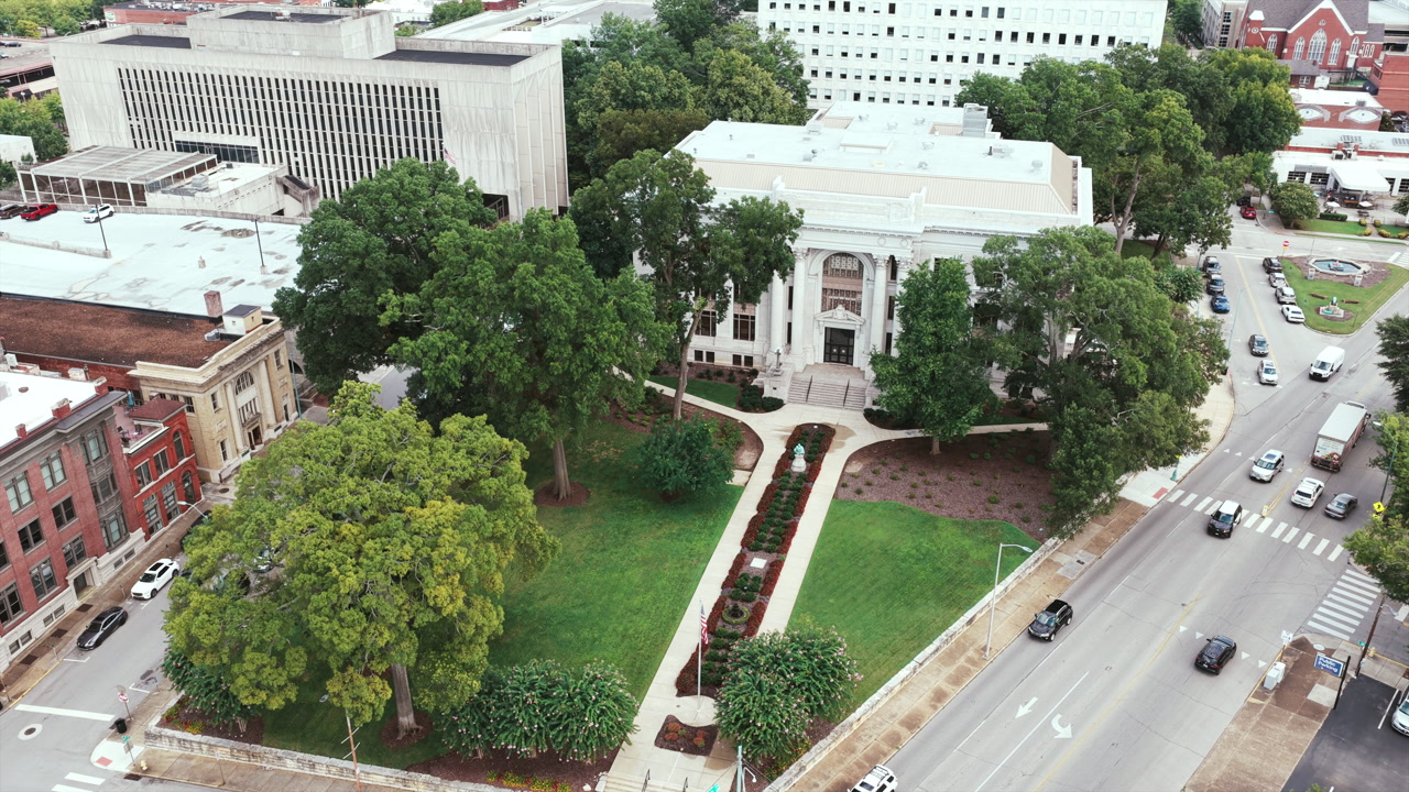 Aerial drone view of downtown Chattanooga highlights a historic courthouse framed by trees, lawns, and urban streets.