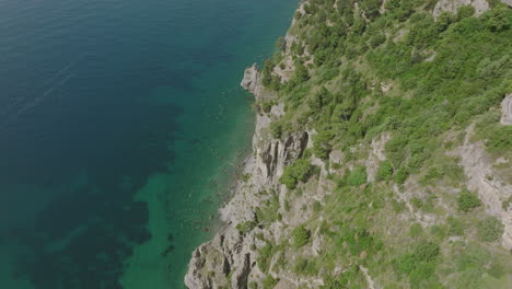 Aerial-footage-on-the-Amalfi-coast-showing-cars-on-a-windy-road-and-the-mountains-meeting-the-coast-of-the-Mediterranean-Sea