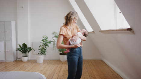 Liebevolle-Mutter-Hält-Schlafendes-Neugeborenes-Zu-Hause-In-Der-Loft-Wohnung