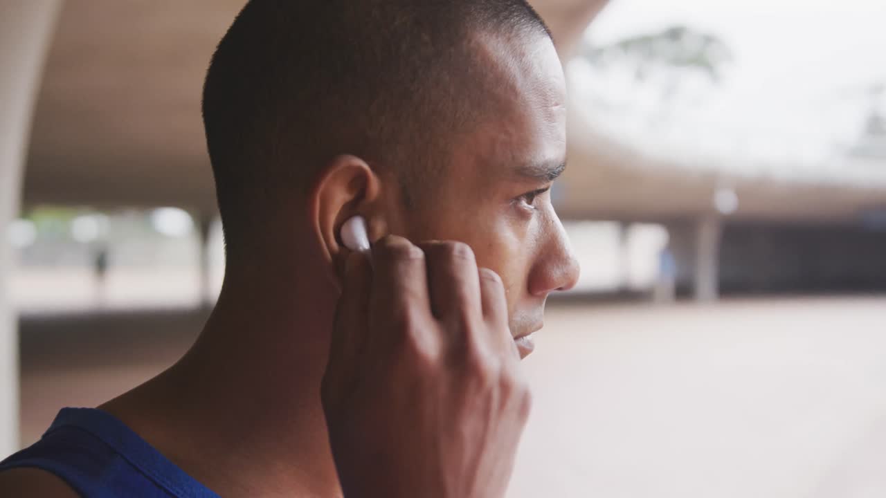 hombre de vista lateral con pierna protésica poniendo auriculares