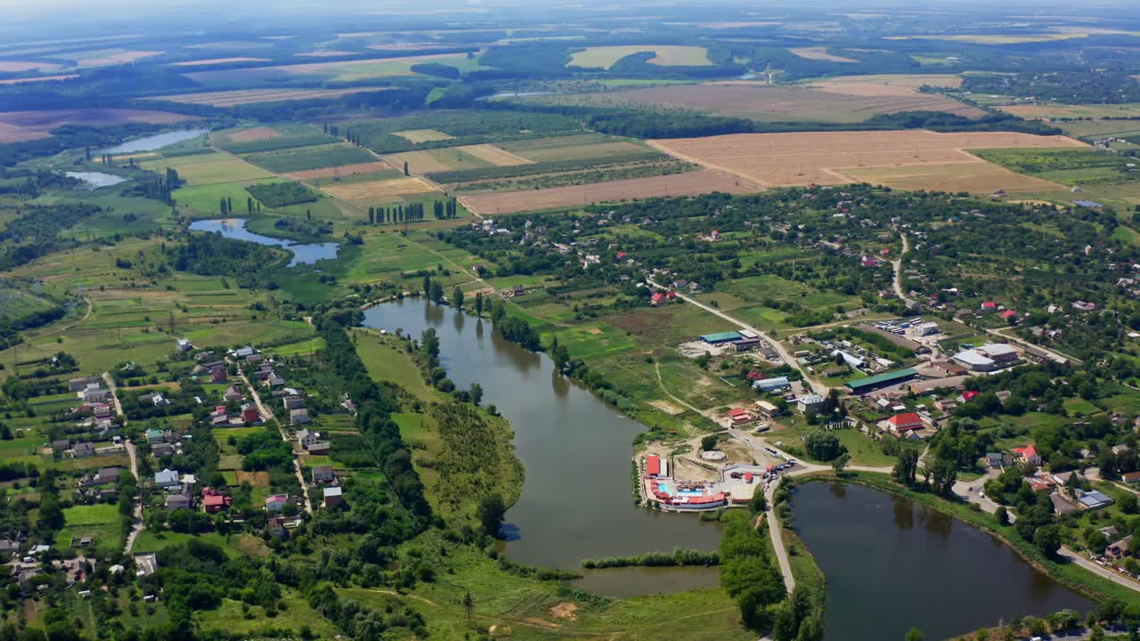 Panoramic landscape in summer. Nature scenery in the countryside. Agricultural fields, lakes and small houses in summer. Aerial view.