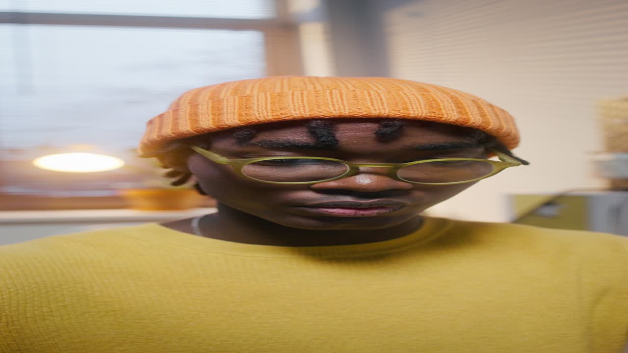 joven con gorra naranja y suéter amarillo