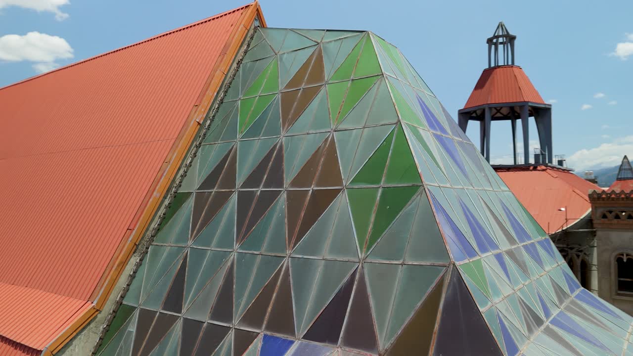 Aerial close-up shot reveals the unique architectural details of the mosaic multi-colored triangular glass panel roof on the Sagrario de San Sebastian Cathedral