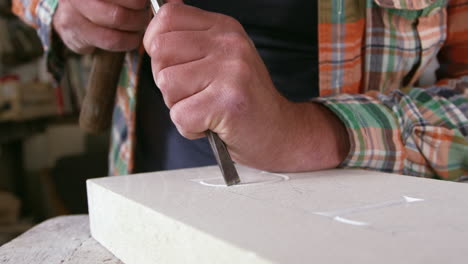 stone mason at work on carving in studio shot on red camera