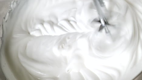 making whipped cream at home for baking with an electric hand mixer, close up