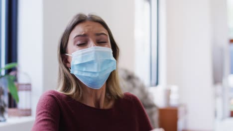 Woman-wearing-face-mask-sneezing-on-her-elbow