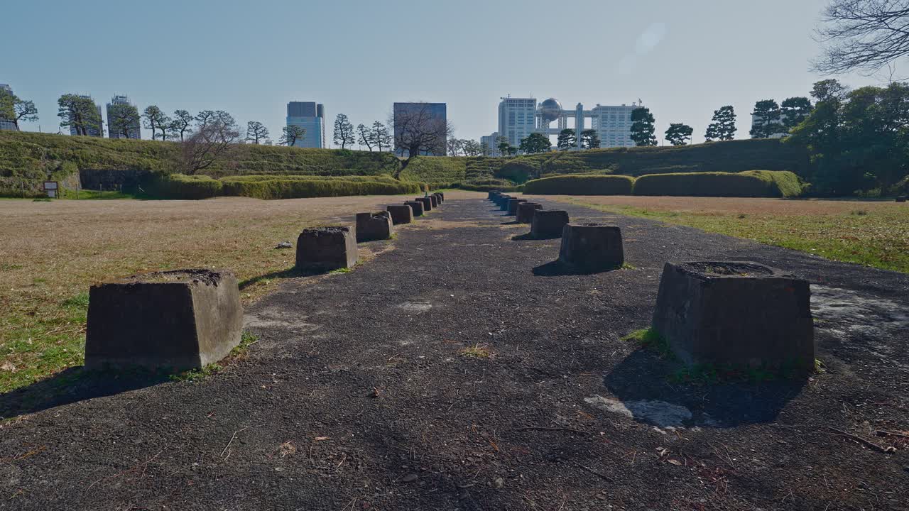 Gamle steinfundamenter ved det historiske Shinagawa tredje batteri-område i Odaiba. En kontrast mellom historiske ruiner og en moderne bysilhuett