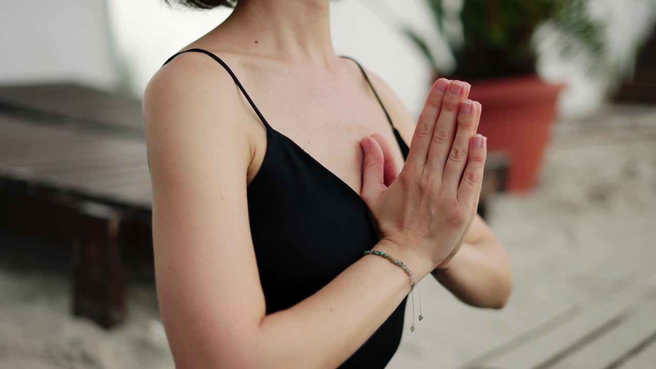 Cropped view of female's hands in meditation on the beach