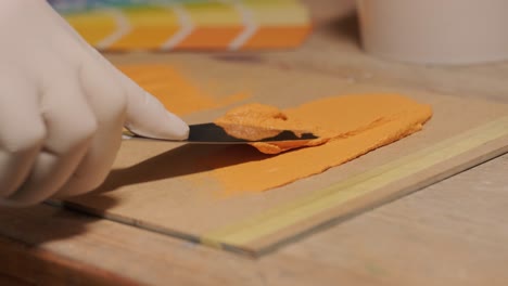 a worker applies a paint sample to a palette for color verification