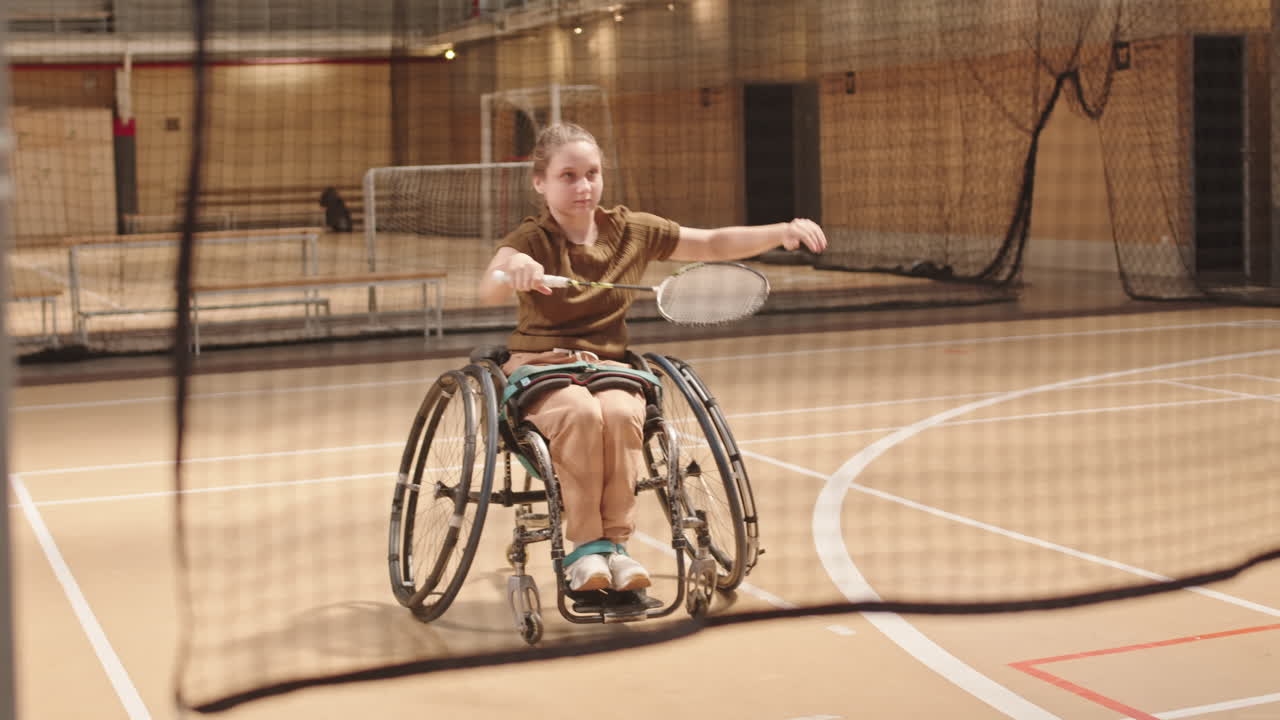 Girl in Wheelchair Practicing with Badminton Racket