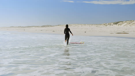 woman running towards surfboard on the sea 4k
