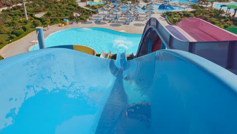 boy riding down an slide in a water park