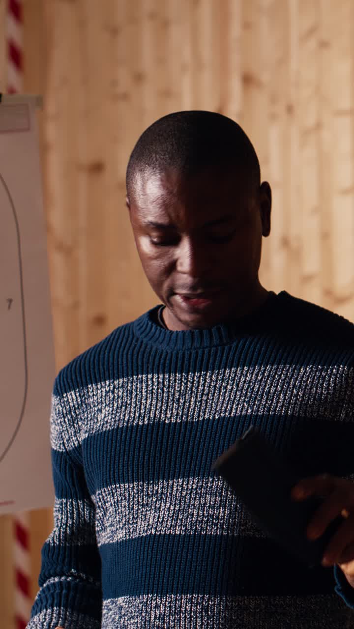 Vertical video Shooting range safety officer demonstrating how to safely reload rifle