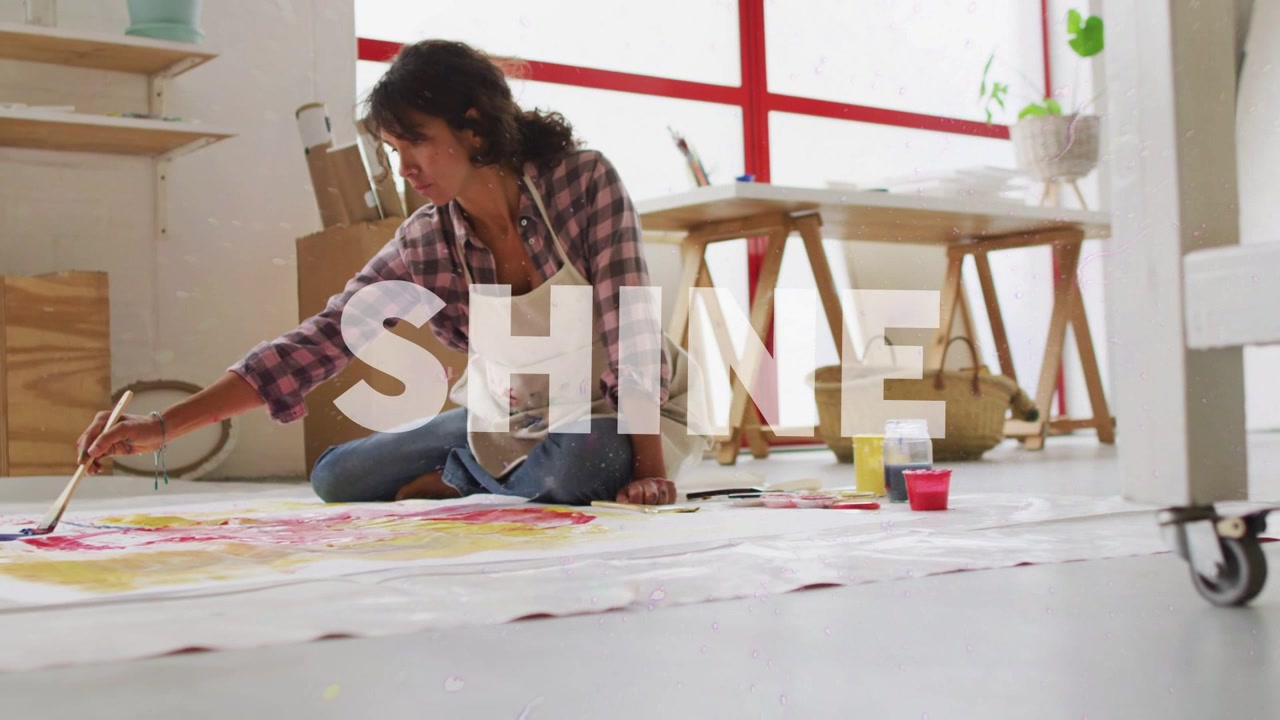 Sun flare arcing frame sparking SHINE overlay while woman artist painting canvas, making bright art
