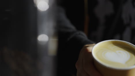 barista holding a cup of latte