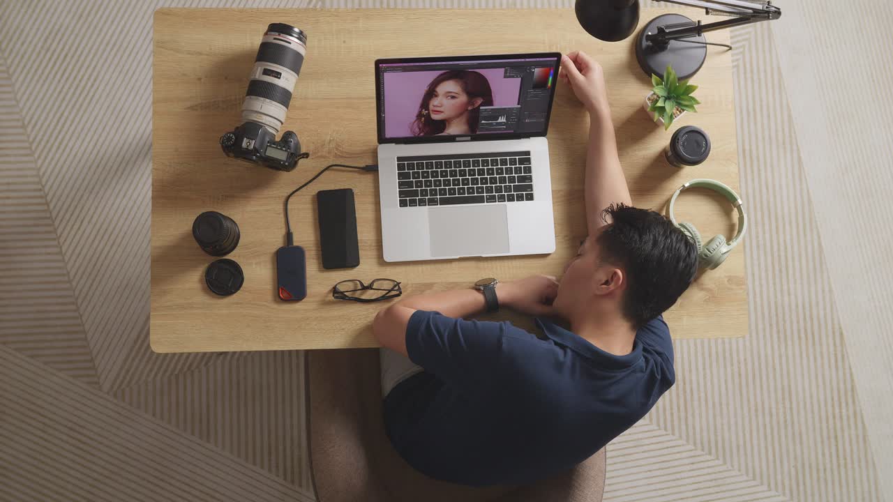 Top View Of Asian Male Editor Sleeping While Sitting In The Workspace Using A Laptop Next To The Camera Editing Photo Of A Female At Home