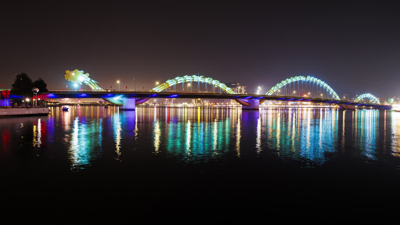 A static night timelapse of Da Nang’s Dragon Bridge as it changes colors, capturing the vibrant lights and city atmosphere