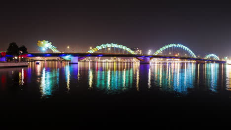 a static night timelapse of da nang’s dragon bridge as it changes colors, capturing the vibrant lights and city atmosphere