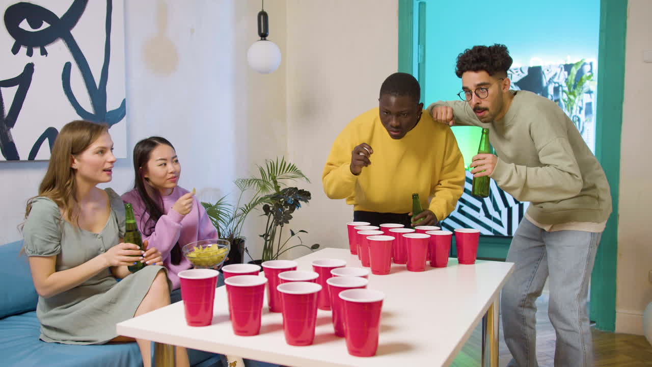 felices jóvenes amigos multiétnicos jugando al pong de cerveza en casa