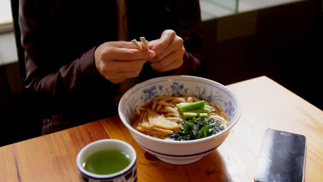 mujer comiendo fideos en un restaurante de 4k