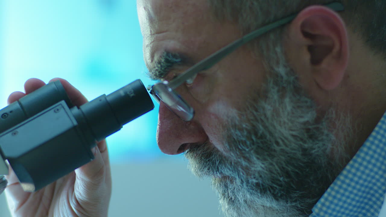 Scienziato che guarda attraverso un microscopio