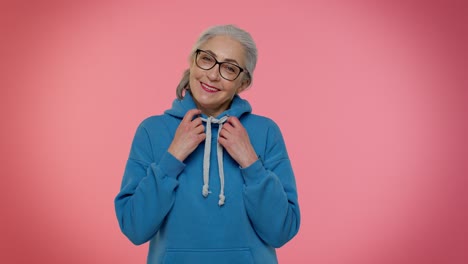 Cheerful-lovely-senior-old-gray-haired-woman-in-casual-blue-hoodie-smiling,-looking-at-camera