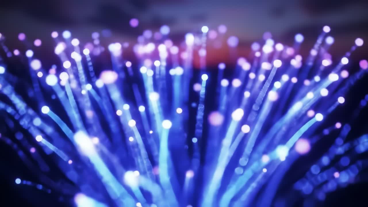 Bright bursts of blue and purple lights explode against a dark sky as the sun sets over the ocean. The vibrant fireworks create a stunning spectacle during a summer festival celebration.