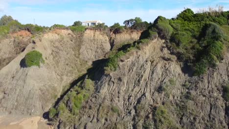 calmer aerial drone flight fly forwards drone shot over the coastline wave in canyon to a house on cliff paradise wild nature dream beach corfu greece autumn 2021 cinematic 1080 60p by philipp marnitz