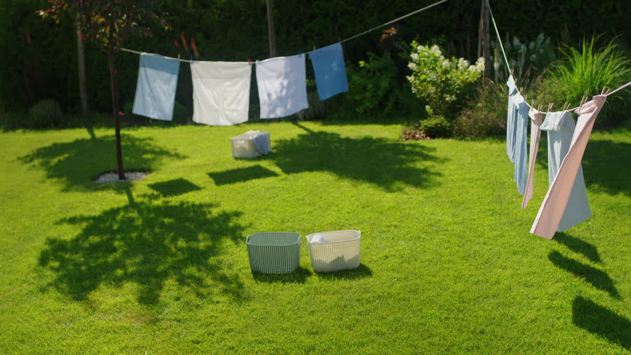 뒷마당 정원에서 옷줄에 세탁기를 건조시키는 것