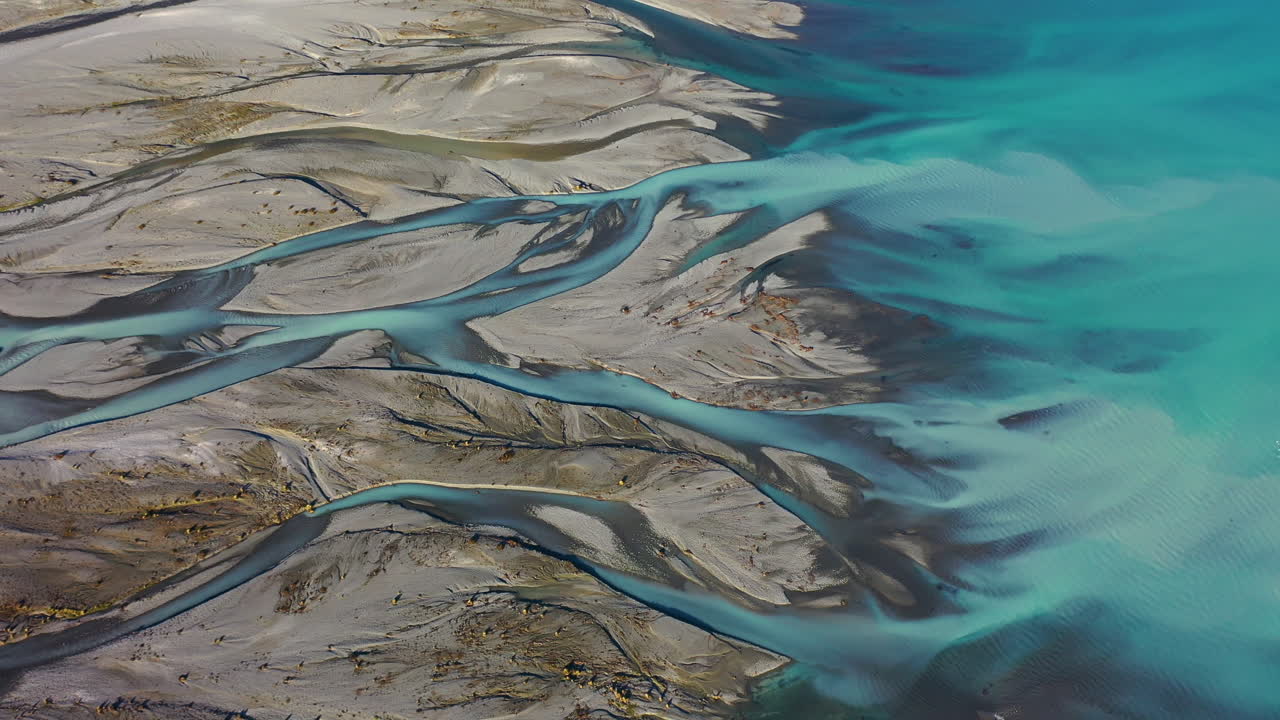 Stunning aerial drone view of the turquoise water of Lake Pukaki meeting the Tasman River delta on New Zealand's South Island