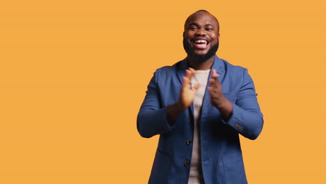 man happily clapping hands, applauding, studio background