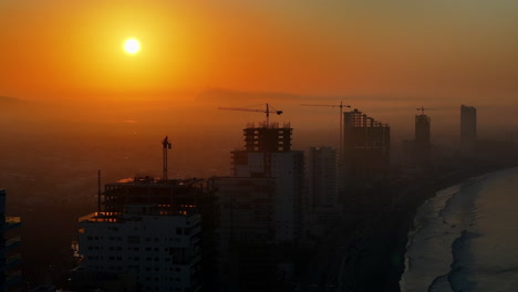 a golden hour beachside view with high-rise buildings under construction in mazatlán sinaloa mexico