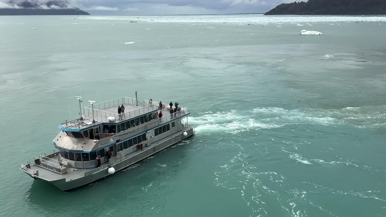 Experience an unforgettable adventure in Glacier Bay, Alaska as a tour boat navigates through pristine waters. Breathtaking views of glaciers and mountains await in this remote paradise.