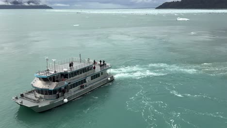 experience an unforgettable adventure in glacier bay, alaska as a tour boat navigates through pristine waters. breathtaking views of glaciers and mountains await in this remote paradise.