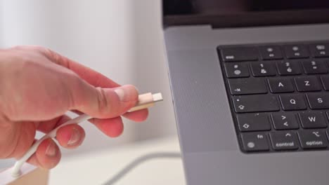 una mano entra en la escena de primer plano y conecta un adaptador usb-c para otros periféricos