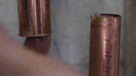 extreme closeup of a man's finger applying flux to a copper pipe before soldering