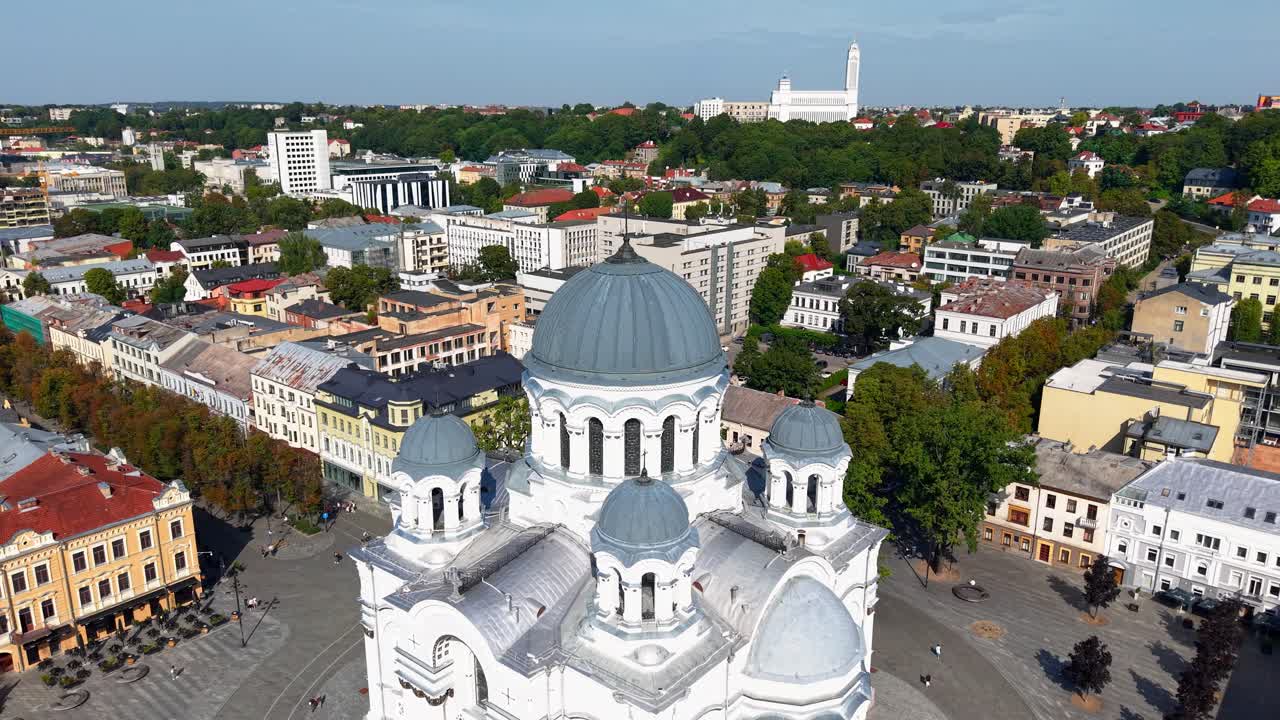 Aerial view of the St. Michael the Archangel Church and Laisvės Alėja in Kaunas, Lithuania on a clear, sunny day. The historic church stands prominently amidst the modern cityscape