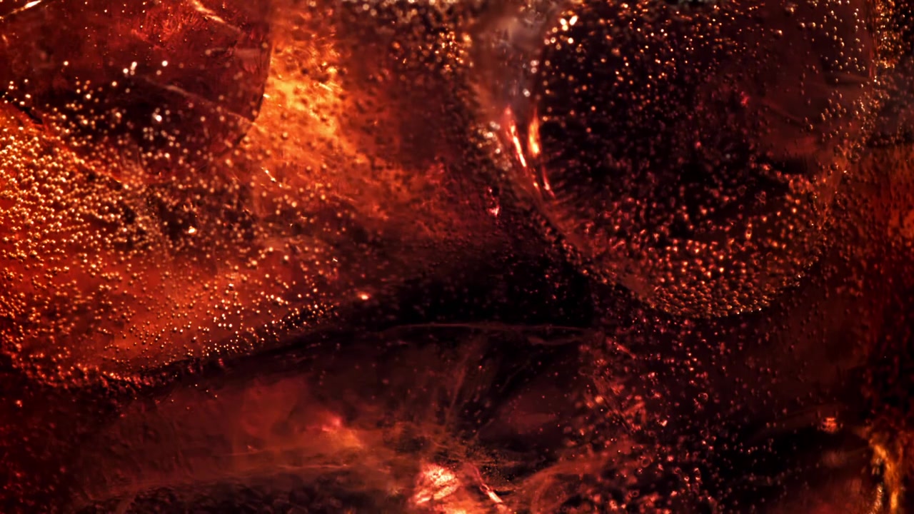 Primo piano macro di cola frizzante con ghiaccio e bollicine che salgono